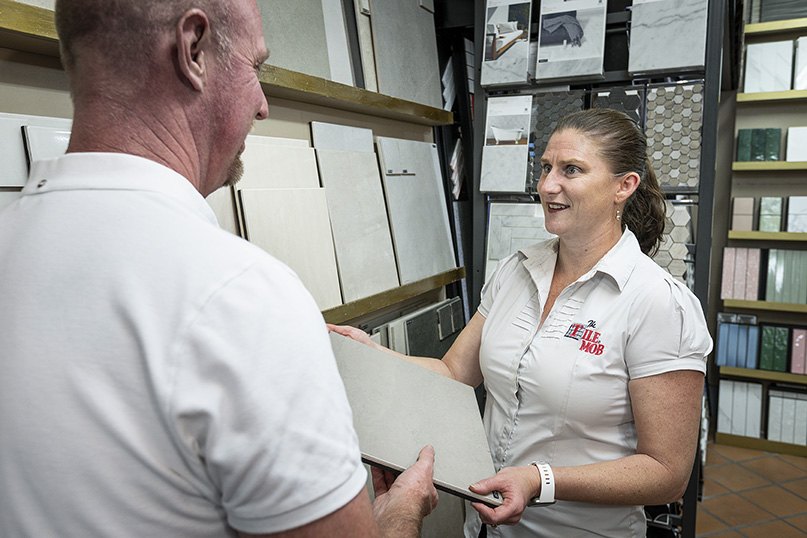A Tile Mob stylist helping a customer choose tiles in the Mitchelton showroom